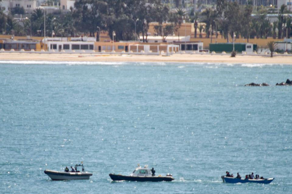 Momento en el que la Guardia Civil traslada la patera al puerto, de fondo el paseo marítimo de Melilla. / J.P