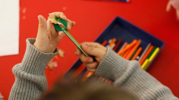 Un niño saca punta a su lápiz en una escuela española. / Unicef