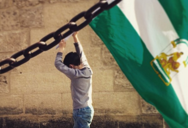 Un niño prota la bandera de Andalucía en una protesta contra el gobierno de Rajoy. / S.R