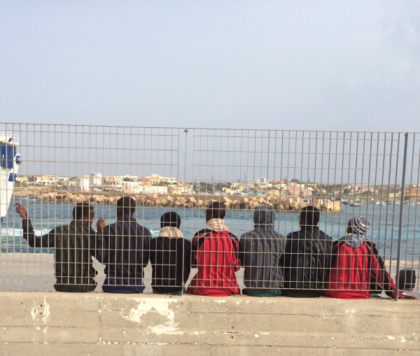 MIGRANTES TRAS LAS BARRERAS DEL PUERTO DE LAMPEDUSA/ S.R