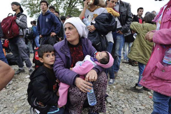 Una mujer con sus hijos busca refugio en la frontera de la ex República Yugoslava de Macedonia y Grecia. Foto: ACNUR/Mark Henley